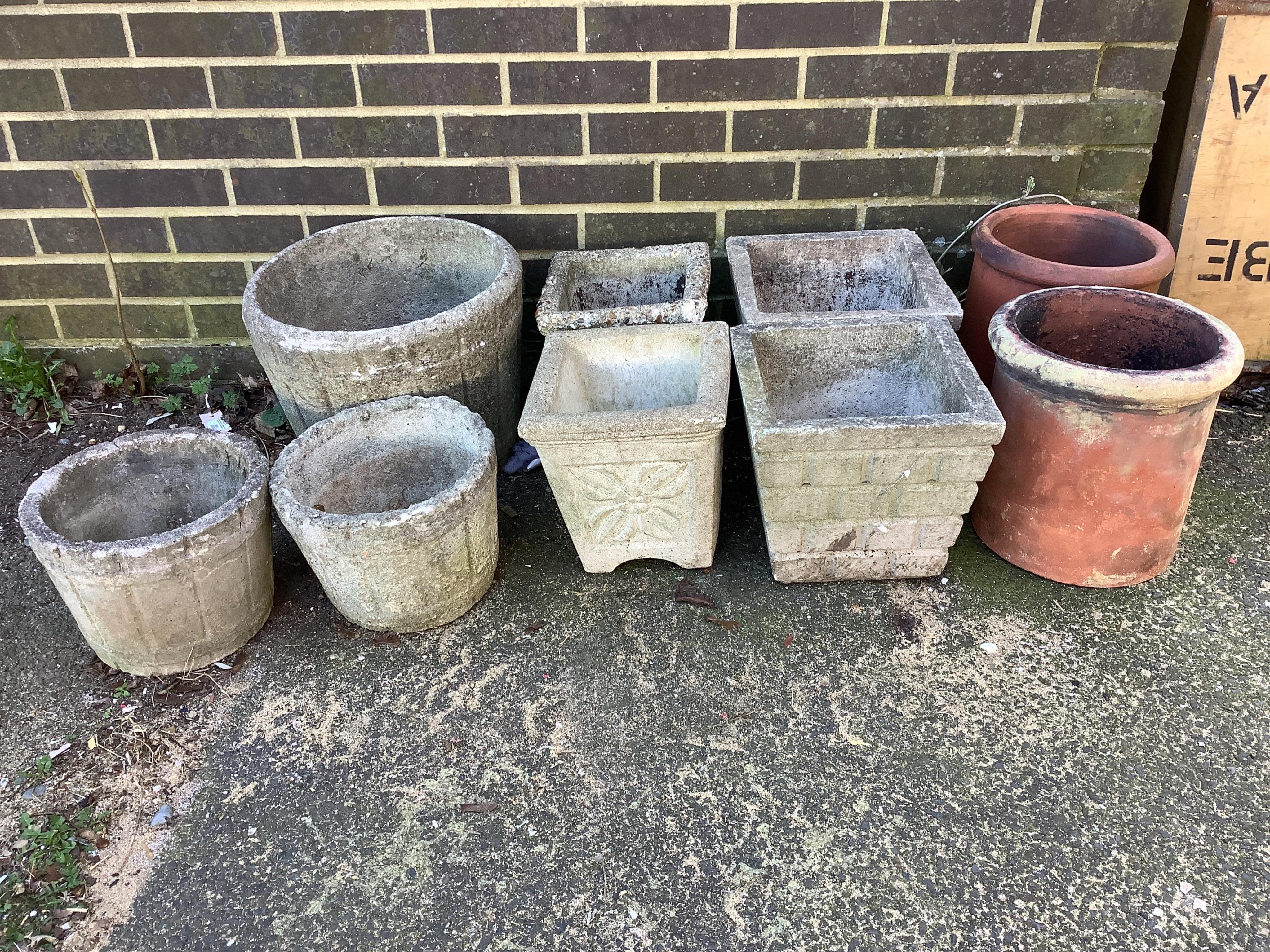 Seven reconstituted stone garden planters and a pair of terracotta forcers, largest diameter 40cm. Condition